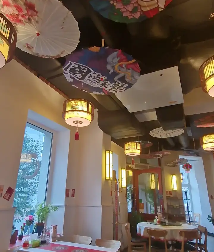 Sala z parasolkami pod sufitem i stolikami przy oknach